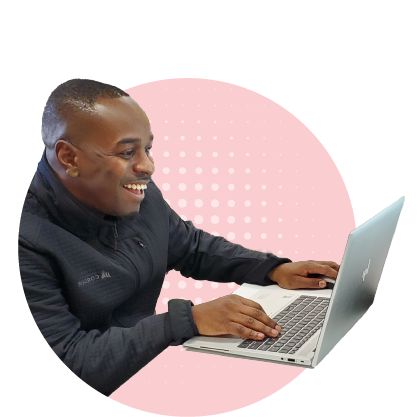 Technology Program Area: image of a man smiling as he's working on a laptop computer.